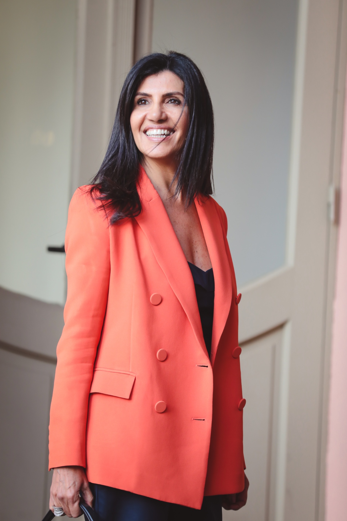 Angela Di Verbeno sorrindo, blazer terracota